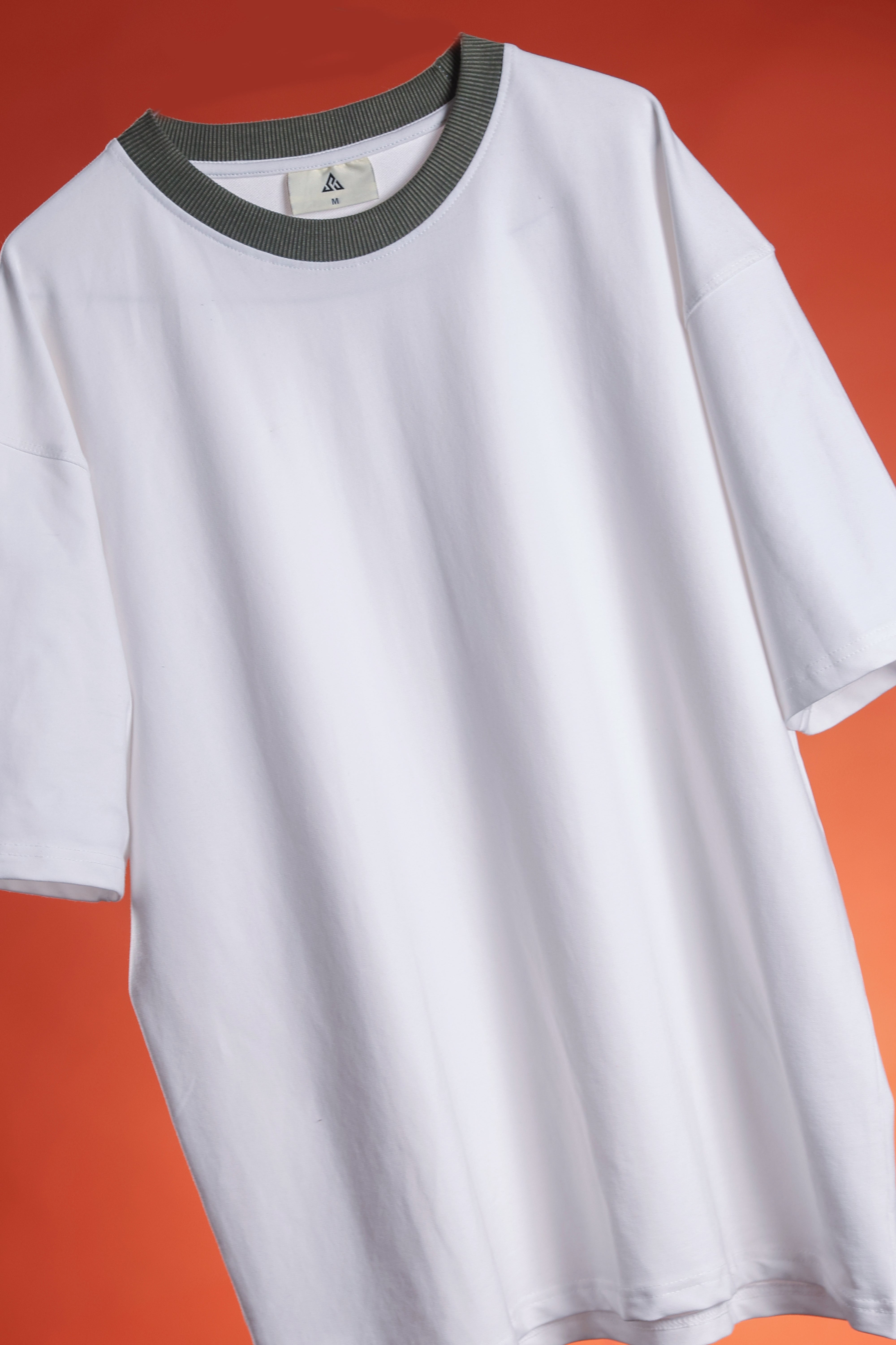 White t-shirt with gray neckline on a red background