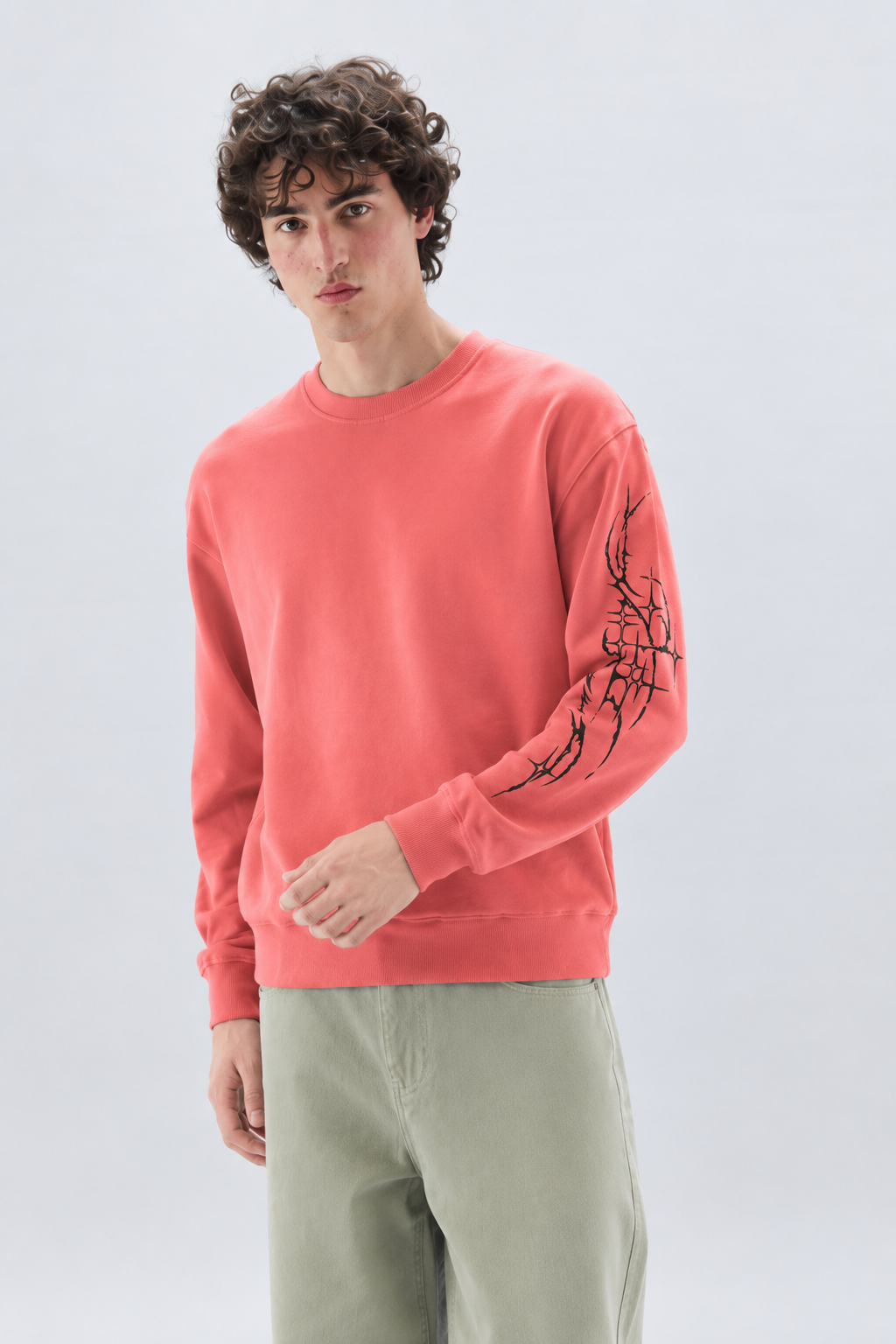 Tragic Bloom full-sleeve tee in dusty rose — three-quarter view on model, ribbed collar and sleeve thorns.