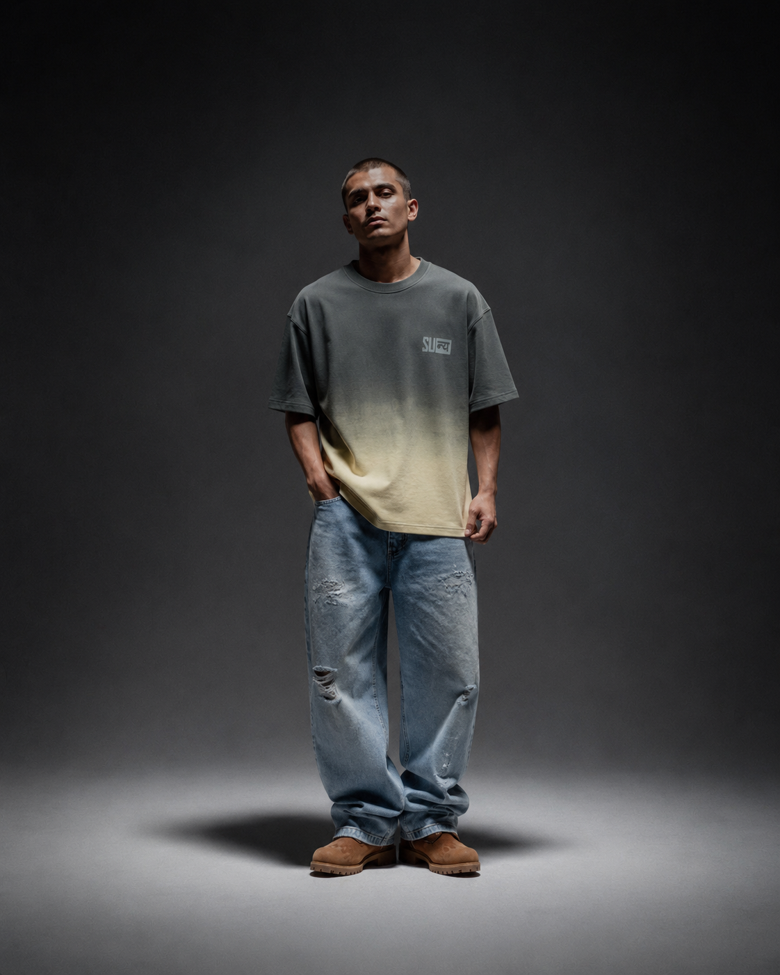 Ombrix tee in olive fading to sage — front view on model with hands drawn behind, spotlit on a dark set