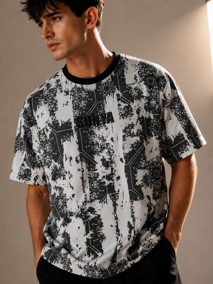 A man wearing a short-sleeve crewneck t-shirt with a black and white abstract circuit board pattern, featuring the brand name 'BURGA' printed across the chest.