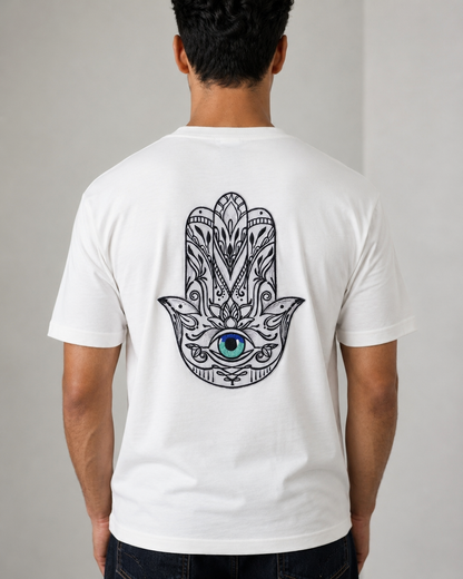A man viewed from behind wearing a white short-sleeve t-shirt with a large black Hamsa hand graphic featuring a blue and green eye on the back.