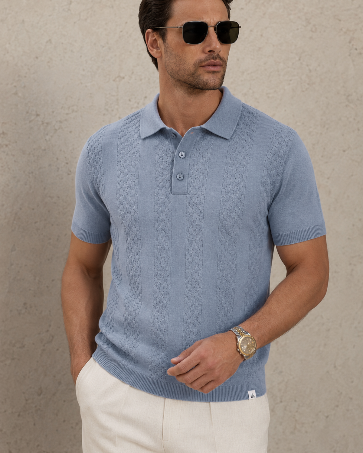CORD knit polo in slate — front view cropped from chest to hip, woven hem label at the ribbed hem
