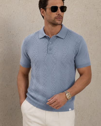 CORD knit polo in slate — front view cropped from chest to hip, woven hem label at the ribbed hem