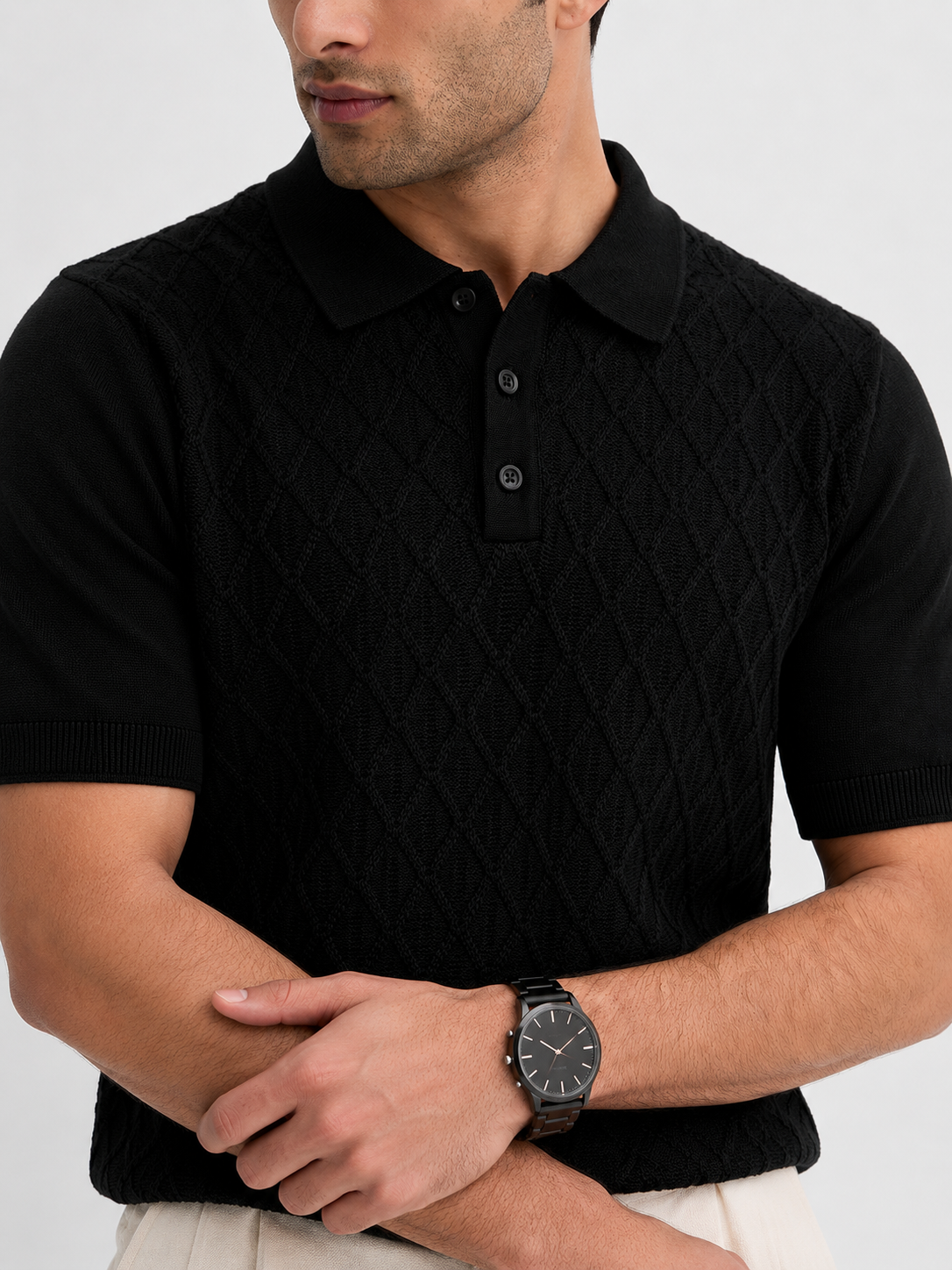 HIVE Knit Polo in black — torso close-up with arms folded, ribbed cuffs and textured knit across the chest