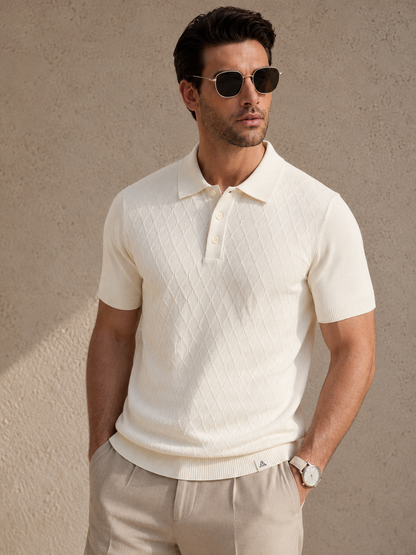 HIVE Knit Polo in cream — front view on model, sunglasses on, hands in the pockets of oatmeal linen trousers