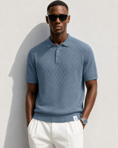 HIVE Knit Polo in slate — front view on model, hands in the pockets of white pleated trousers
