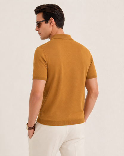 LEAF Knit Polo in camel — three-quarter back view on model, head in profile, one hand in a pocket