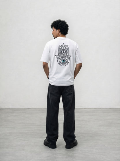 Person wearing a white t-shirt with a design on the back, standing against a plain background