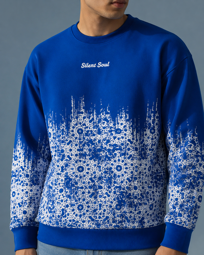 A man wearing a royal blue crewneck sweatshirt with a white floral pattern gradient fading from the hem to the cuffs, featuring the text 'Silent Soul' on the chest.