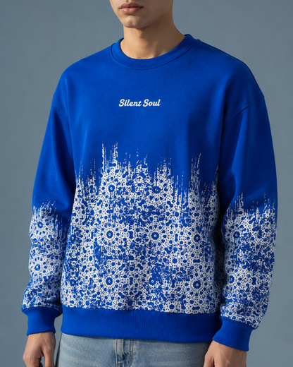 A man wearing a royal blue crewneck sweatshirt with a white floral pattern gradient on the lower half and sleeves, featuring the text 'Silent Soul' printed in white on the chest.
