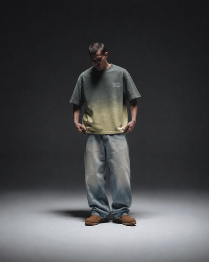 Ombrix tee in olive fading to sage — full-length front view on model, arms hanging loose at his sides