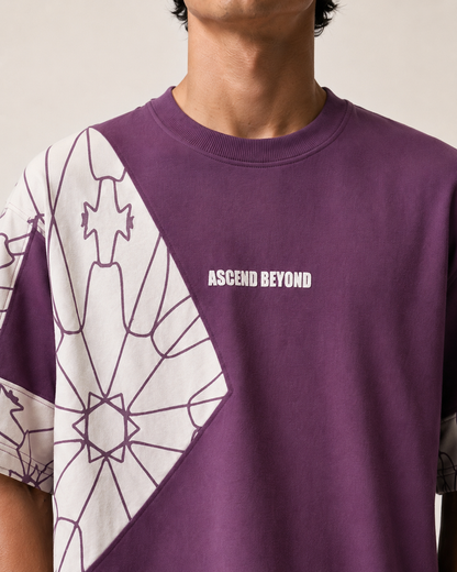 A close-up of a person wearing a purple short-sleeve t-shirt with a white geometric line pattern on the left side and the text 'ASCEND BEYOND' printed in white on the chest.