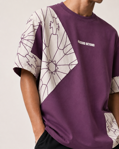 A close-up of a person wearing a purple short-sleeve t-shirt with white geometric line-art panels on the sleeves and a small white 'ASCEND BEYOND' logo on the chest, against a light beige background.