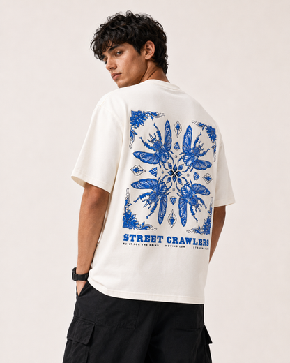 A man wearing a white t-shirt with a large blue graphic print on the back, featuring the brand name 'Street Crawler'.
