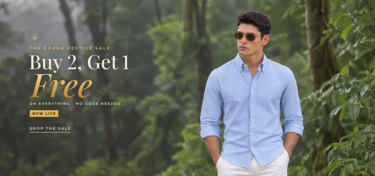 The Grand Festive Sale: Buy 2, Get 1 Free on everything, no code needed. A man in the Powder Oxford shirt and gold-rim sunglasses in a misty green forest. Shop the sale.