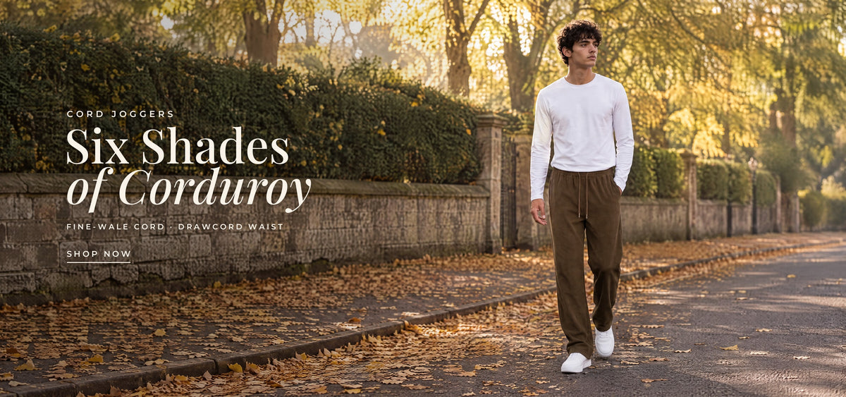 Cord joggers: six shades of corduroy, fine-wale cord with a drawcord waist. A man in MRIDA brown cord joggers walking down an autumn avenue. Shop cord joggers.