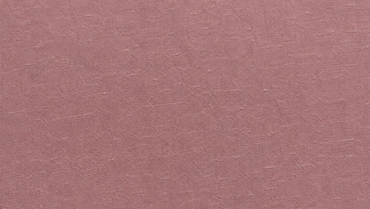 Edge-to-edge close-up of dusty rose banana fabric showing its natural slub texture