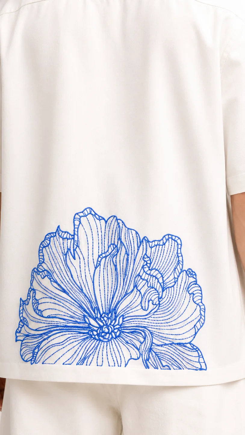 Close-up of the cobalt-blue line-embroidered flower on the Vinelet shirt