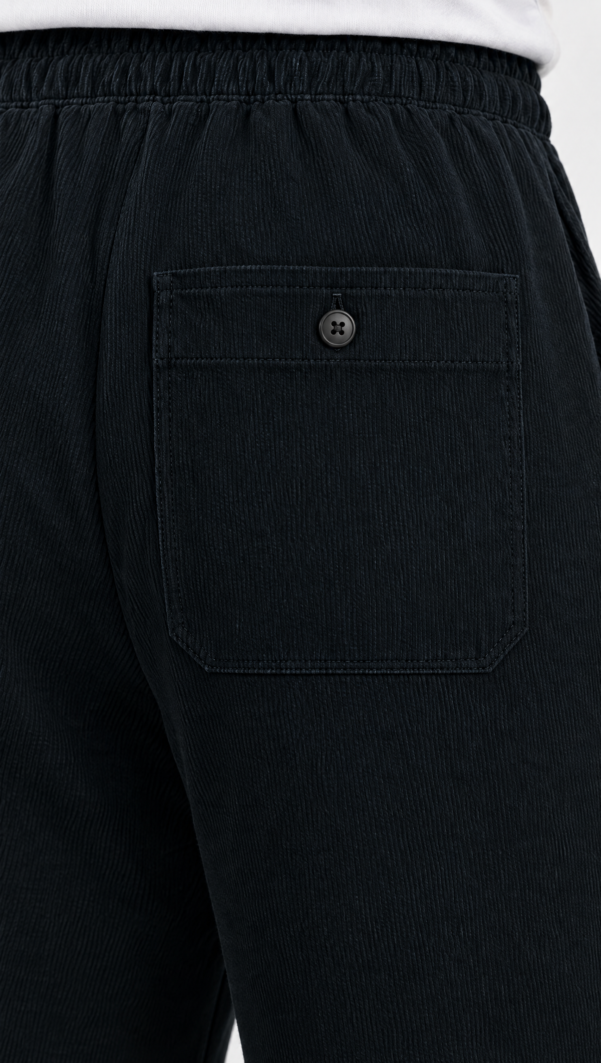 The buttoned back patch pocket of the BHASMA joggers in near-black charcoal