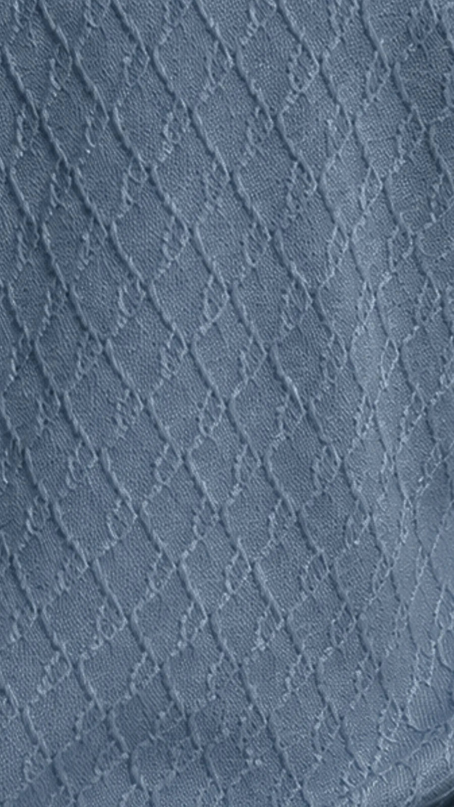 Close-up of the slate HIVE knit: fine twisted lines forming an open diamond lattice