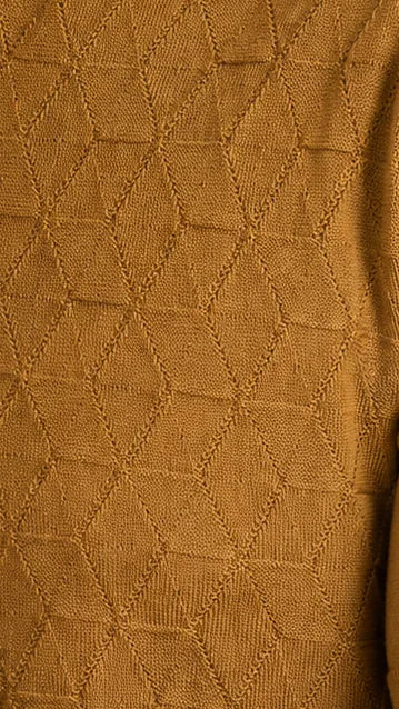 Close-up of the camel LEAF knit: small faceted triangles, edge to edge