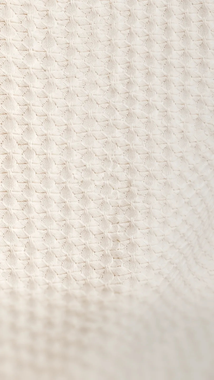 Close-up of the cream TILE knit: raised blocks set in offset brick rows