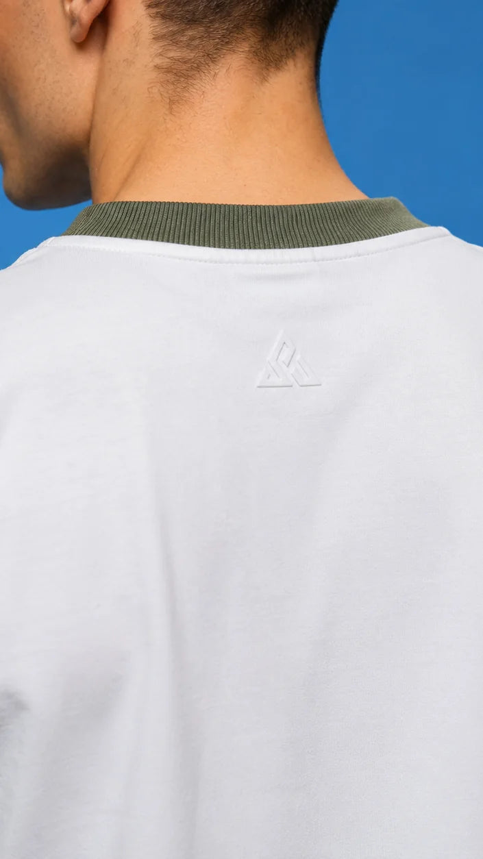 Back view of a white tee with an olive rib collar and a tonal embossed emblem