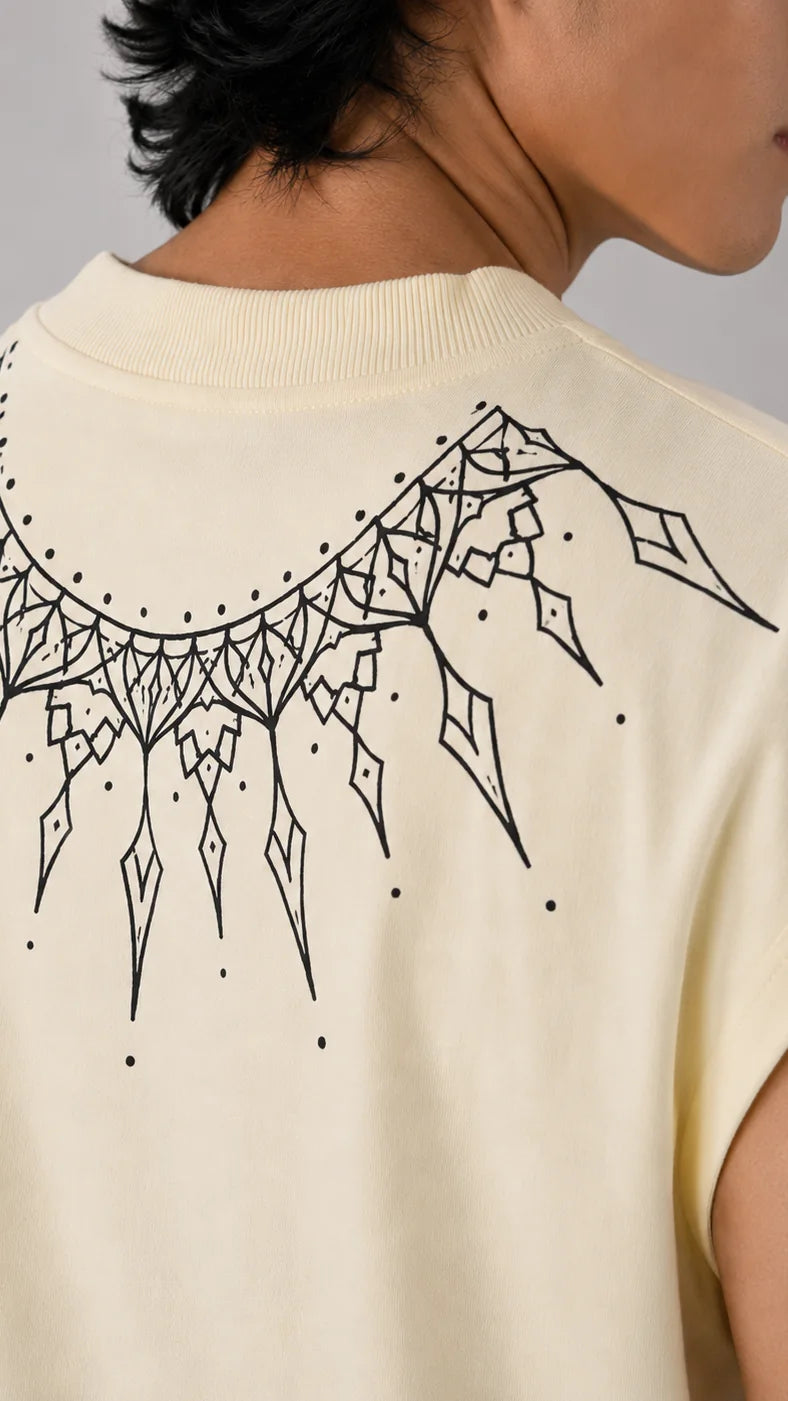 Close-up of a black geometric sunburst arc printed across the upper back of a cream sleeveless tee