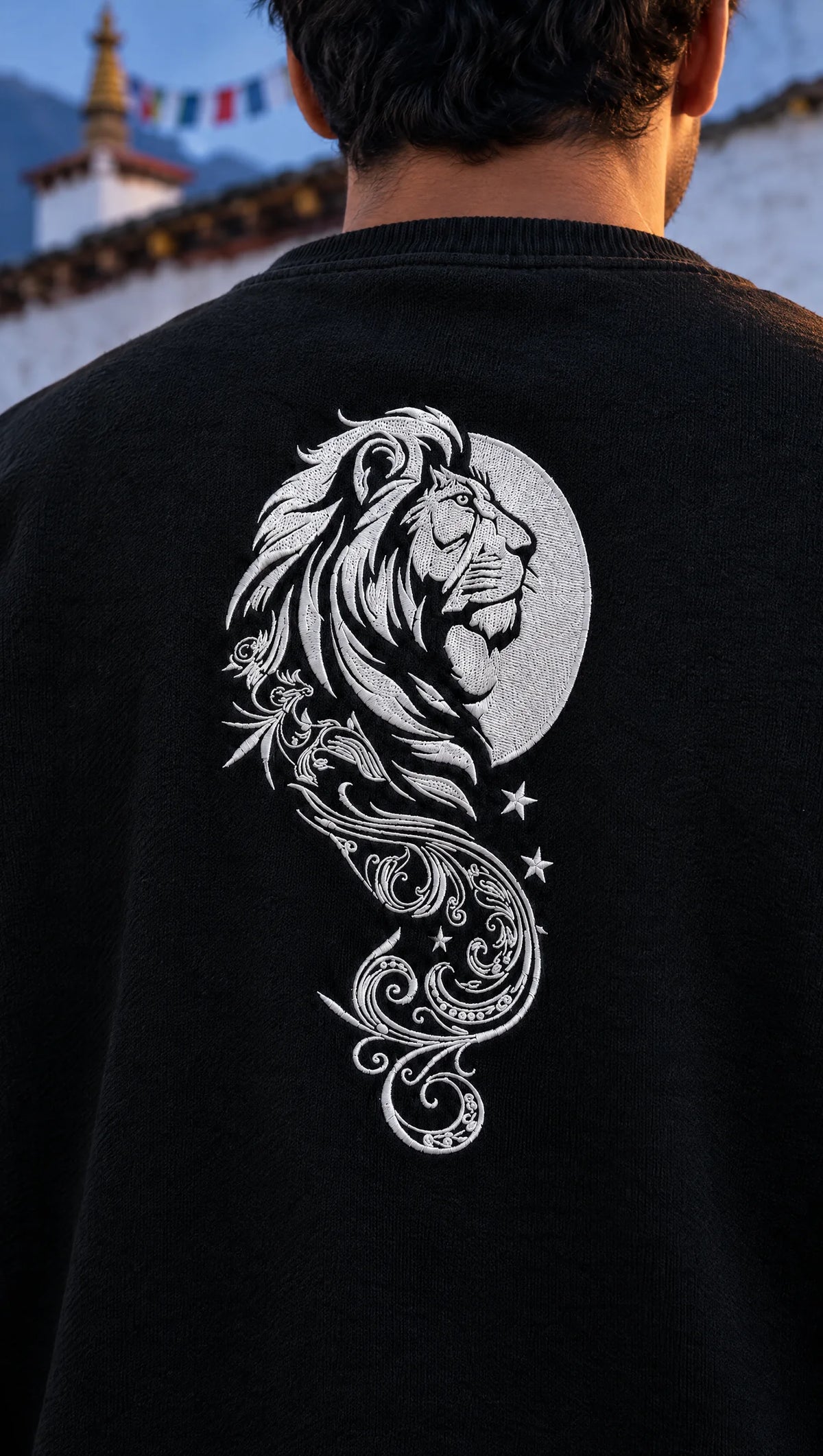 Close-up of the white lion, moon and filigree print on the back of the black Lion's Majesty sweatshirt