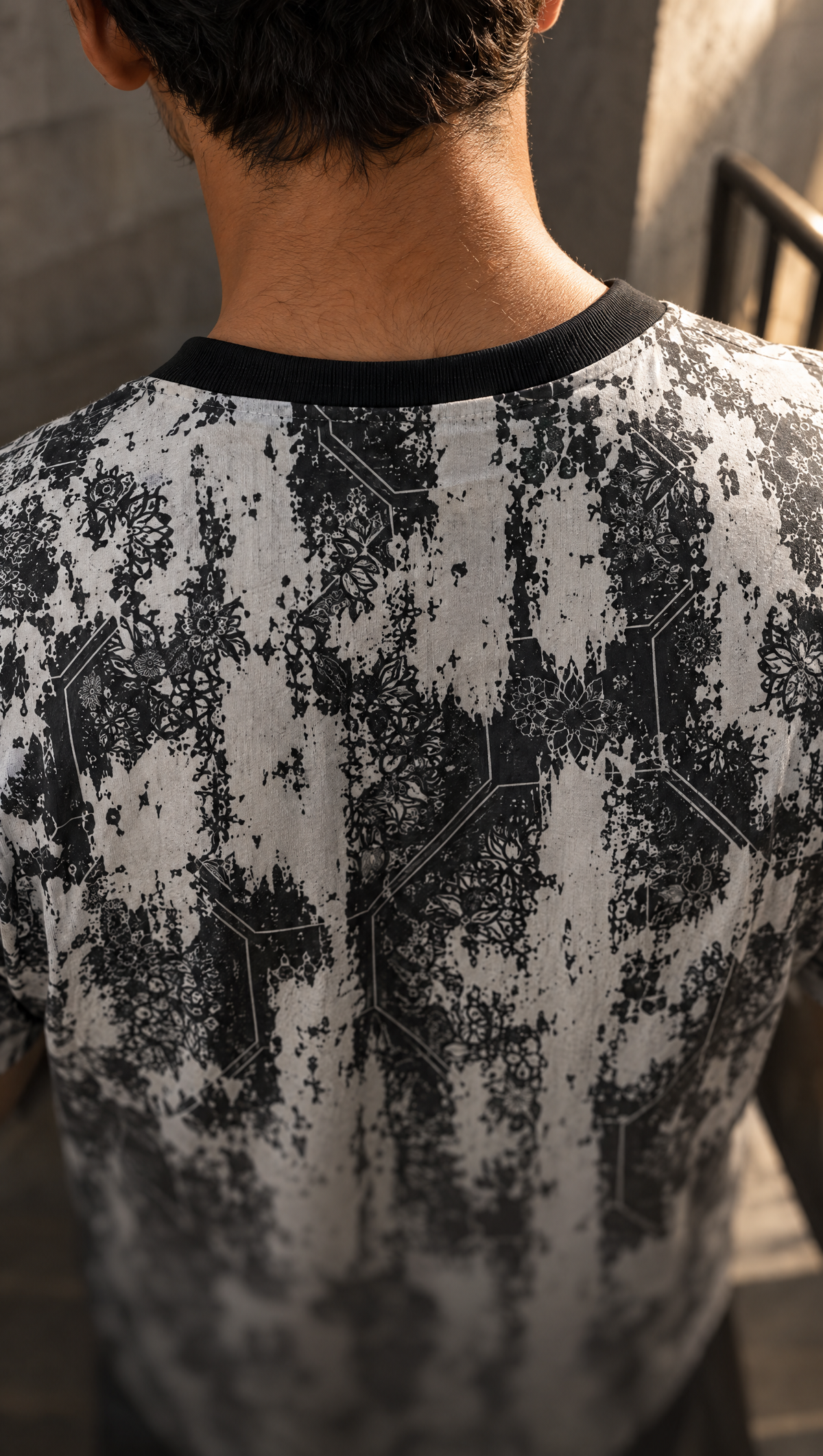 The black ribbed crew of the KSHAYA tee against its black-and-white hex-grid print