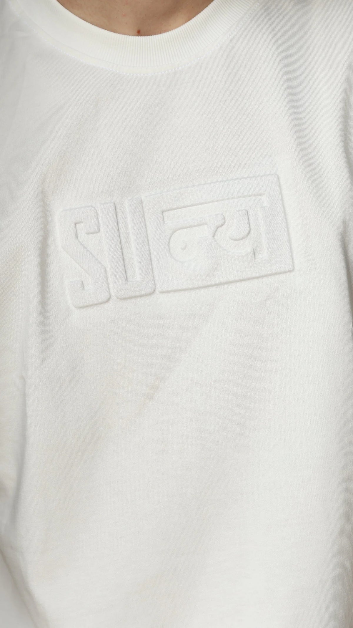 Close-up of the boxed शून्य mark embossed bone white on bone white